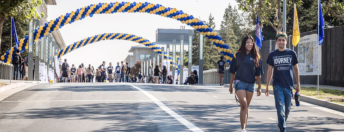 Two students walking towards their dorms after attending festivities held on Scholars Lane